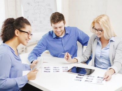 smiling team with table pc and papers working