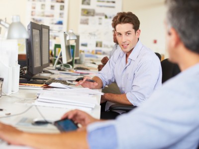 Man Working At Desk In Busy Creative Office
